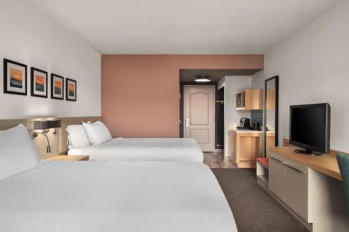 a hotel room with two beds and a flat screen tv at Hilton Garden Inn Wooster in Wooster
