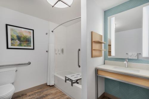 a bathroom with a sink and a toilet and a mirror at Hilton Garden Inn Wooster in Wooster