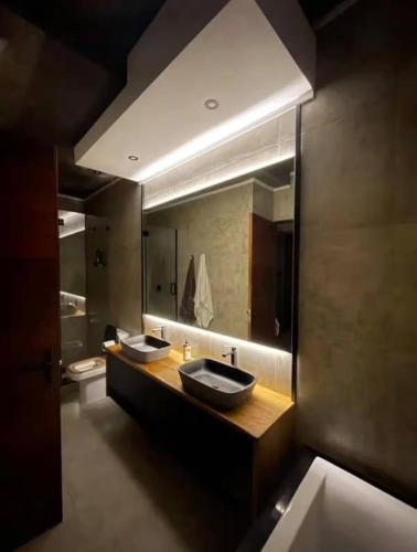 a bathroom with two sinks and a large mirror at The Concrete Edit in Benoni