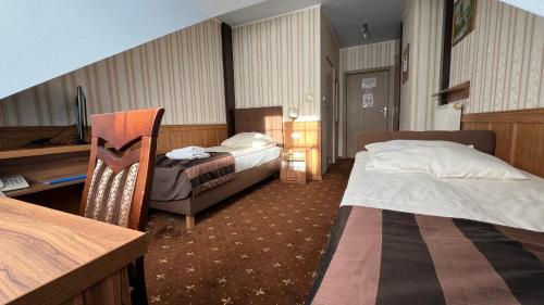 una camera d'albergo con due letti e una scrivania di HOTEL NIAGARA a Konin