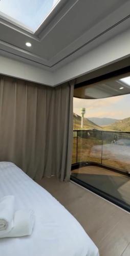 a bedroom with a bed and a large window at Kolsay tany in Kurmenty