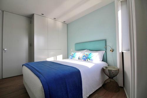 a bedroom with a large bed with a blue wall at RestOnDouro Oporto Family in Valbom