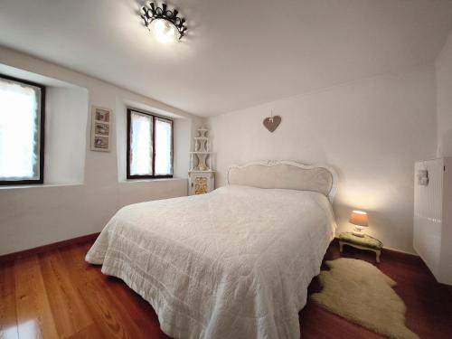 a bedroom with a white bed and a window at La casa nel borgo in Cavaso del Tomba