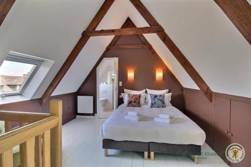 a bedroom with a large bed in a attic at Kerguntuil in Pleumeur-Bodou