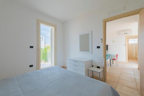 a bedroom with a bed and a desk and a chair at Residence Le Piscine in Nardò
