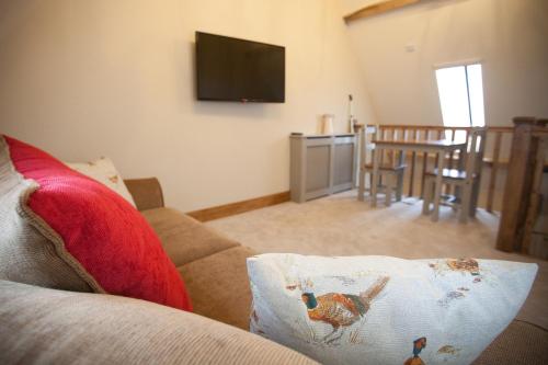 a living room with a couch with a chicken pillow on it at The Plough Inn in Stalisfield