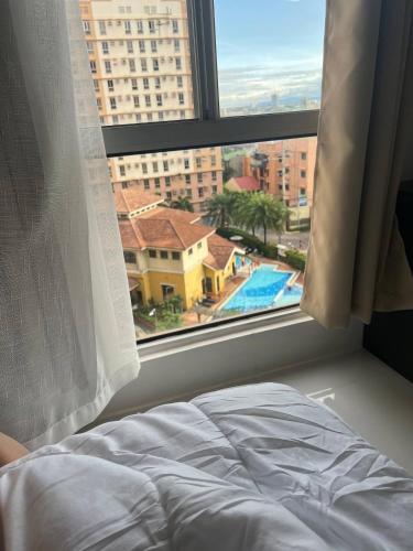 a bedroom with a window with a view of a pool at Welcome to lucky7suites in Manila