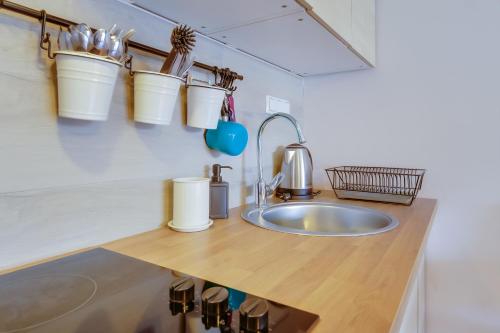a kitchen with a sink and buckets on the wall at Move&Rest Slunj in Slunj