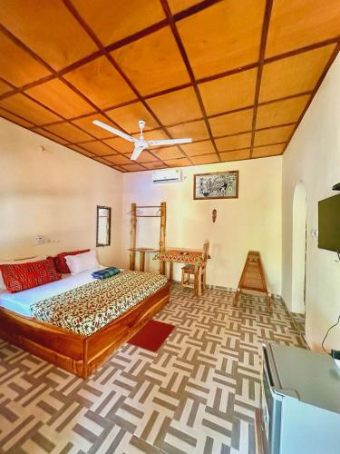 a bedroom with a bed and a tv in a room at Hotel Eyram Kpalime in Palimé