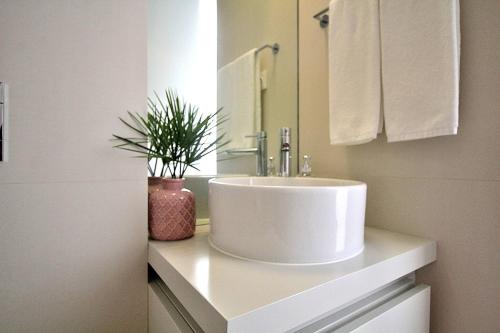 a white bathroom sink with a potted plant on a counter at RestOnDouro Oporto Flat in Valbom