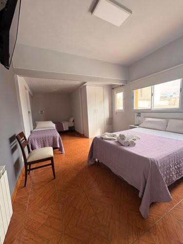 a large bedroom with two beds and a chair at Hotel Florida in Concordia