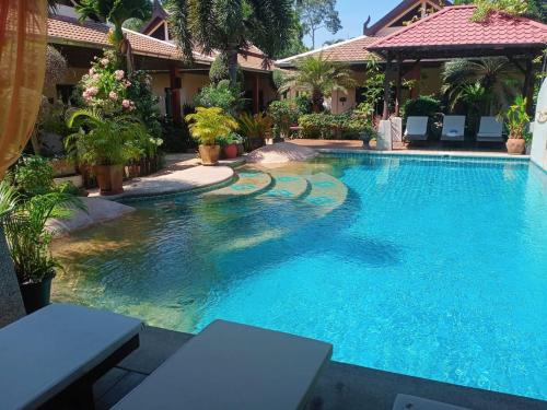 a swimming pool in front of a house at Baan Tropicana in Mae Nam