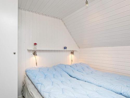 a large bed in a white room with two lights at 6 person holiday home in Ringkøbing in Ringkøbing