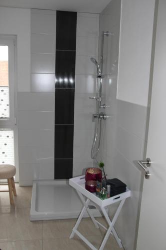 a white bathroom with a shower and a table at Ferienhaus "Dorf-Glück" in Brilon