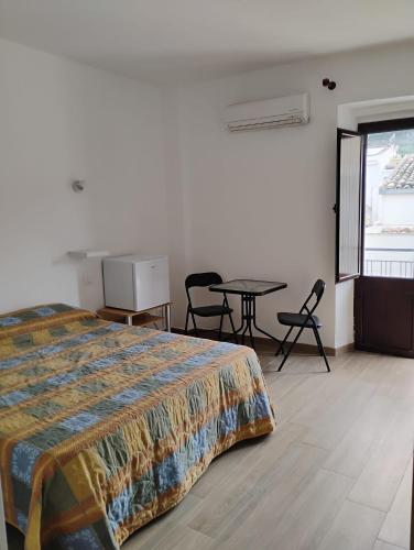 a bedroom with a bed and a table and chairs at Dentro Scopello - Casa Vacanze in Scopello