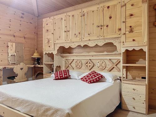 a bedroom with a large bed with wooden cabinets at Lagorai Wood Apartment in Telve