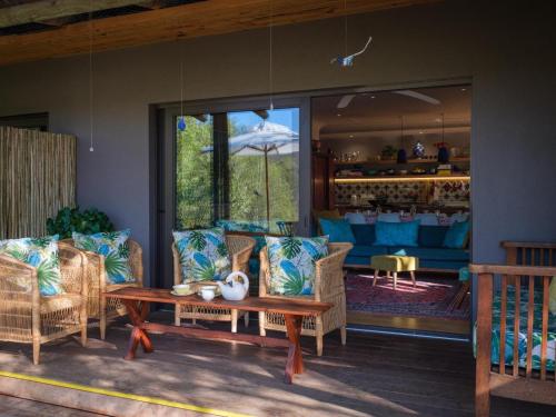 a patio with a table and chairs and a bar at Kamala Karoo Sanctuary in Barrydale