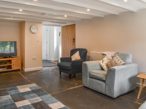 a living room with two chairs and a television at Uk47758 - Horseshoe Cottage in Launceston