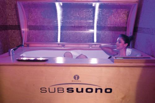 a woman sitting in a bathtub in a restaurant at Hotel Tropis in Tropea