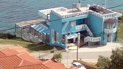 a blue house next to the water at Delfini in Akhladherí