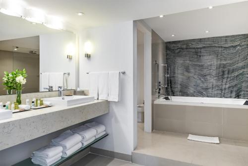 a bathroom with a tub and two sinks and a bath tub at Hilton Cartagena in Cartagena de Indias