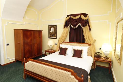 a bedroom with a large bed with a canopy at Hotel Leopold I in Novi Sad