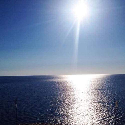 an image of the sun shining on the water at Delfini in Akhladherí