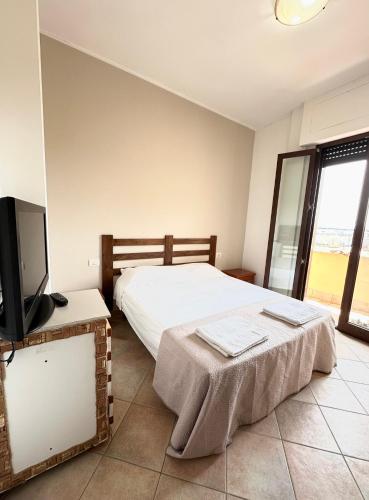 a bedroom with a bed and a flat screen tv at ALT alloggio turistico in Focene