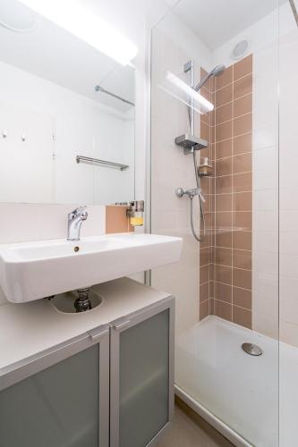 a white bathroom with a sink and a shower at Premier Acte - Chambre Spacieuse Sur Les Allées in Toulouse