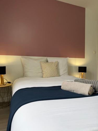 a bedroom with a large white bed with two lamps at Le Thannaron in Bourg-lès-Valence