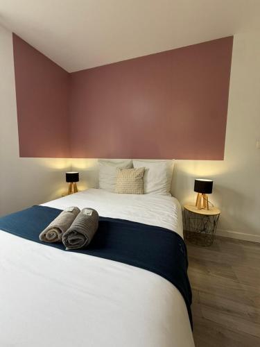 a bedroom with a bed with two towels on it at Le Thannaron in Bourg-lès-Valence