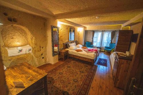 a bedroom with a bed and a table in a room at Aja Cappadocia Cave Hotel-Special Class in Ürgüp