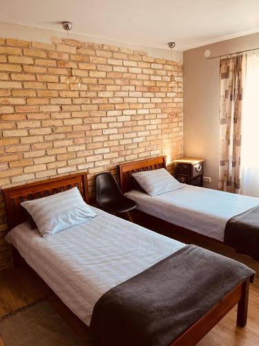 a room with two beds and a brick wall at Old Willows in Ventspils