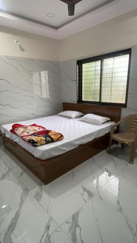a bedroom with a bed and a window and a chair at VISHNU DATTA HOMESTAy in Bandanwāda