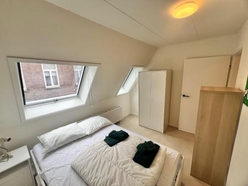 a bedroom with a bed with two green pillows on it at Appartement Daalseweg in Nijmegen