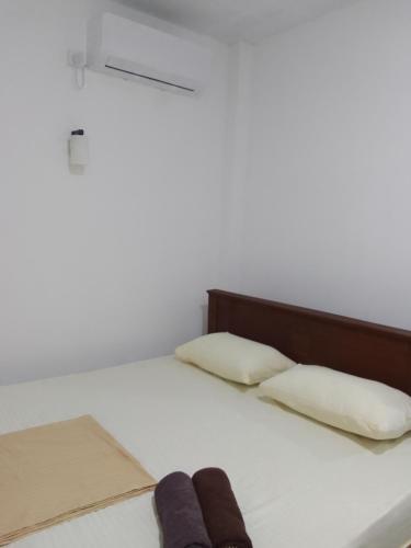 a bed with two pillows and two towels on it at Ocean whisper residence in Ahangama