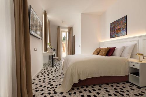a bedroom with a large bed and a hallway at Heritage Hotel Lucia in Dubrovnik