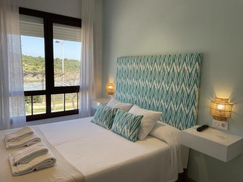 a bedroom with a large bed with a window at El Escondido de Zahara in Zahara de los Atunes
