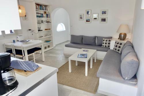 a living room with a couch and a table at Villa B - Kamari Village in Aliko Beach