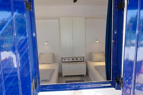 a reflection of a bedroom with two beds in a mirror at Villa B - Kamari Village in Aliko Beach