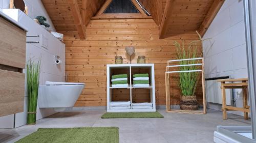a bathroom with wooden walls and a toilet and a sink at Ferienhaus Sepp in Regen