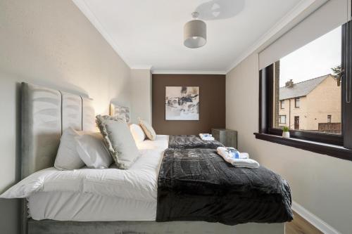 a bedroom with a large bed and a window at Glebe House in Uphall