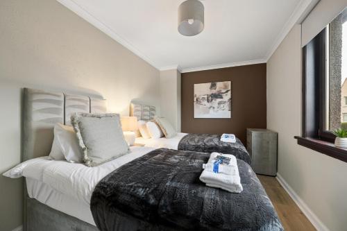 a hotel room with two beds with towels on them at Glebe House in Uphall