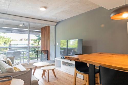 a living room with a wooden table and a couch at Oceana Suites Mansa Inn in Punta del Este