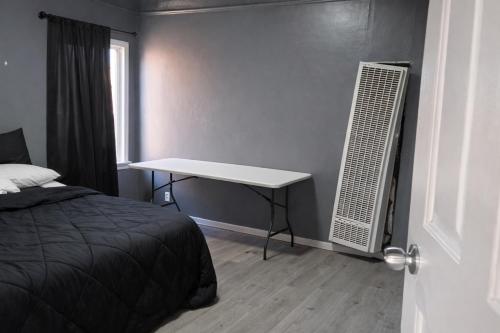 a bedroom with a bed and a desk next to a window at Hoover Stay Close to Bus Routes in Los Angeles