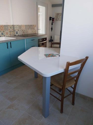 a white table and a chair in a kitchen at Chambre Cocon, bienvenue chez Sylviane in Marennes