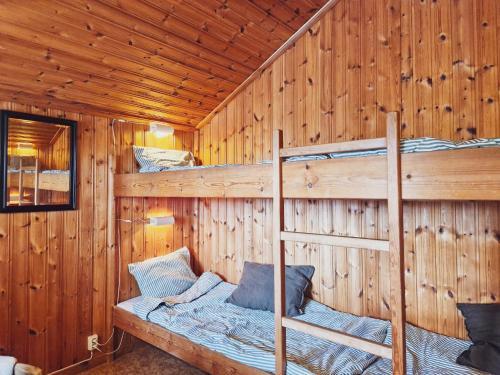 a bedroom with two bunk beds in a wooden cabin at Långseruds Stugby Nature Cabins in Byn