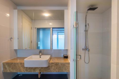 a bathroom with a sink and a shower at Dwija Hotel & Suite in Pattaya South