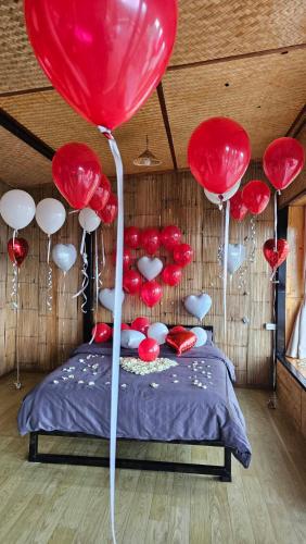 a bedroom with red and white balloons around a bed at Mon Ngo misty haven B2 in Ban Mae Ta Man