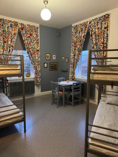 a dorm room with bunk beds and a table at STF Landskrona Hostel in Landskrona